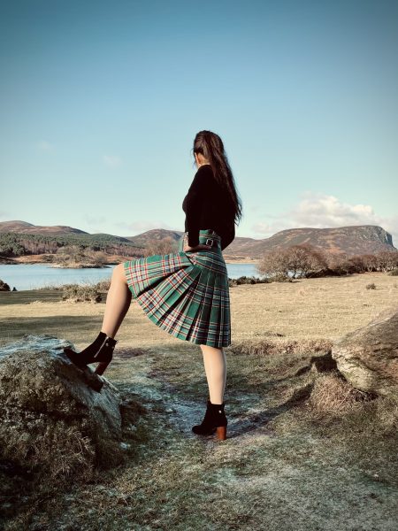 Contact us – Woman in kilt image Conatct Us - A woman standing on the beach looking into the distance wear a kilt and jacket
